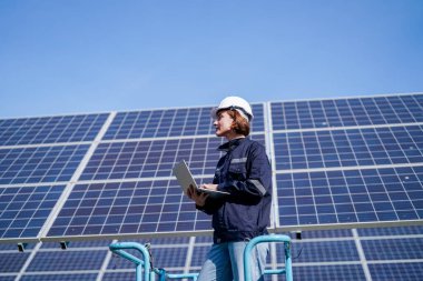 Teknoloji güneş pili, mühendislik servisi fabrikanın çatısında güneş pili kurulumunu kontrol ediyor. teknisyen güneş panellerinin bakımını kontrol ediyor