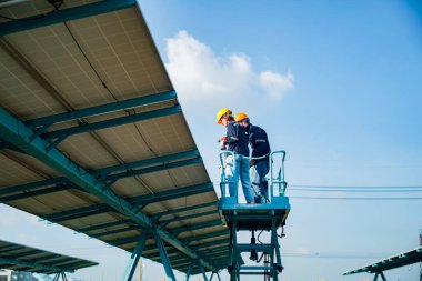 Teknoloji güneş pili, mühendislik servisi fabrikanın çatısında güneş pili kurulumunu kontrol ediyor. teknisyen güneş panellerinin bakımını kontrol ediyor