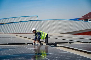 Teknoloji güneş pili, mühendis fabrikanın çatısındaki güneş pilini kontrol ediyor. teknisyen güneş panellerinin bakımını kontrol ediyor