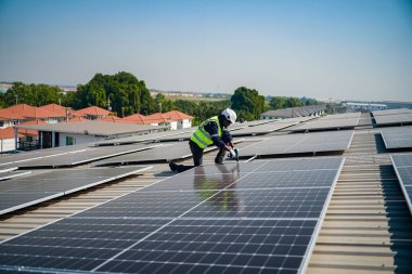 Teknoloji güneş pili, mühendislik servisi fabrikanın çatısında güneş pili kurulumunu kontrol ediyor. teknisyen güneş panellerinin bakımını kontrol ediyor