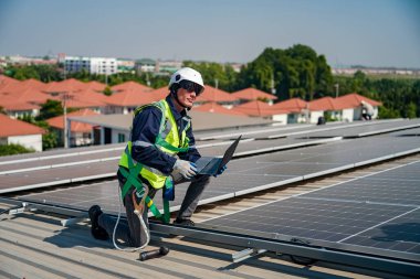 Teknoloji güneş pili, mühendis fabrikanın çatısındaki güneş pilini kontrol ediyor. teknisyen güneş panellerinin bakımını kontrol ediyor