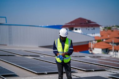 Mühendis, fabrikanın çatısındaki güneş pilini kontrol ediyor. teknisyen güneş panellerinin bakımını kontrol ediyor