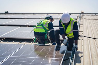 Teknoloji güneş pili, mühendislik servisi fabrikanın çatısındaki güneş pillerini kontrol ediyor. Teknisyenler güneş panellerinin bakımını kontrol ediyor, mühendislik ekibi çalışıyor. 