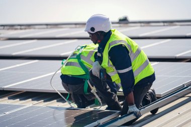 Teknoloji güneş pili, mühendislik servisi fabrikanın çatısında güneş pili kurulumunu kontrol ediyor. Güneş panellerinin bakımını kontrol eden teknisyenler, mühendislik ekibi güneş enerjisi santralinde kontrol ve bakım üzerinde çalışıyor. 
