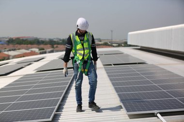 Teknoloji güneş pili, mühendislik servisi fabrikanın çatısında güneş pili kurulumunu kontrol ediyor. teknisyen güneş panellerinin bakımını kontrol ediyor