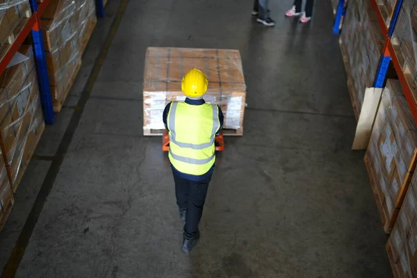 stock image Warehouse workers working in the large logistic distribution warehouse. Worker in reflective clothing working in the warehouse