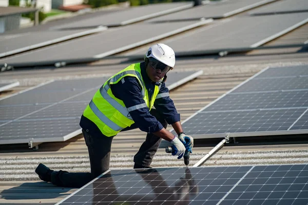 Teknoloji güneş pili, mühendis fabrikanın çatısındaki güneş pilini kontrol ediyor. teknisyen güneş panellerinin bakımını kontrol ediyor