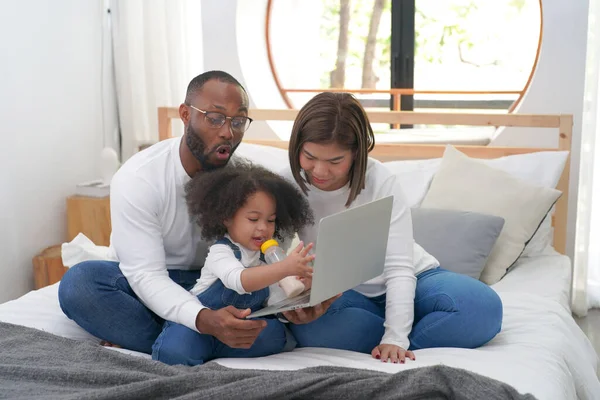 Stock image happy african american child with parents using laptop