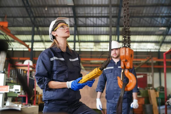 stock image Female empowerment, working female industry technical worker or engineer woman working in an industrial manufacturing factory.