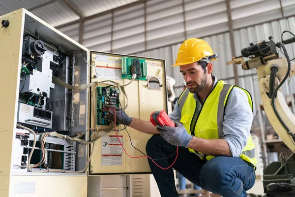 stock image Robotics engineer working on maintenance of modern robotic arm in factory warehouse