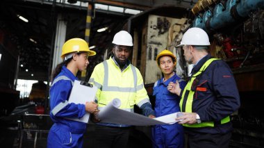 Fabrikadaki makine bakımında mühendisler tartışılıyor. Endüstriyel Mühendisler Grubu, tren ve makine endüstrisi geçmişine karşı plan yapmış. Üst Düzey ile Planlama Çalışılıyor