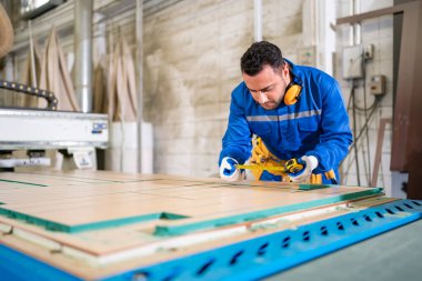 Marangoz atölyede mobilya yapıyor.