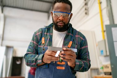 Marangozluk atölyesinde çalışırken Sander 'ı kullanan el işçisi..