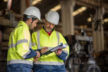 Fabrikadaki sanayi mühendisi işçiler. Mühendisler mühendislik fabrikasında endüstriyel şanzıman monte ediyorlar.