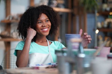 Çömlek atölyesindeki genç Afro kız, işyeri sahibi.