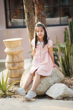 Gülümseyen küçük bir çocuğun portresi. Gülümseyen Asyalı Kız Kafede eğleniyor.