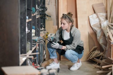 Marangoz DIY atölyesinde çalışan genç ve güzel bir kadın. Küçük işletme sahibi, mobilya fabrikasında çalışan genç bir kadın..