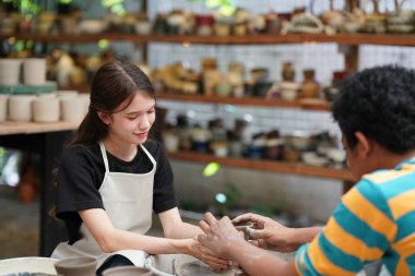 Sanat stüdyosunda çalışan genç bir kadın çömlekçilik işinde.