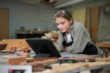 Marangoz DIY atölyesinde çalışan genç ve güzel bir kadın. Küçük işletme sahibi, mobilya fabrikasında çalışan genç bir kadın..