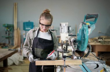 Marangoz DIY atölyesinde çalışan genç ve güzel bir kadın. Küçük işletme sahibi, mobilya fabrikasında çalışan genç bir kadın..