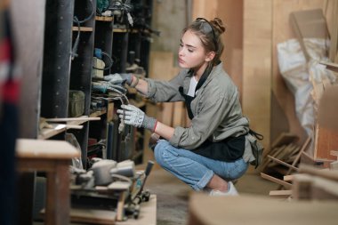 Marangoz DIY atölyesinde çalışan genç ve güzel bir kadın. Küçük işletme sahibi, mobilya fabrikasında çalışan genç bir kadın..