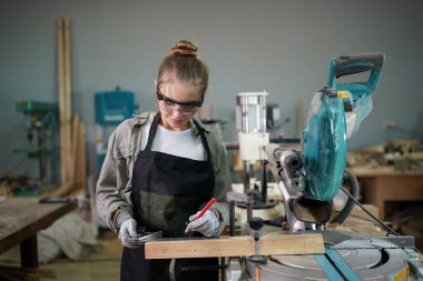 Genç bir kadının küçük işleri. Mobilya atölyesinde çalışan güzel genç bayan.