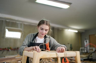 Marangoz DIY atölyesinde çalışan genç ve güzel bir kadın. Küçük işletme sahibi, mobilya fabrikasında çalışan genç bir kadın..