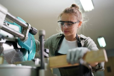 Genç bir kadının küçük işleri. Mobilya atölyesinde çalışan güzel genç bayan.