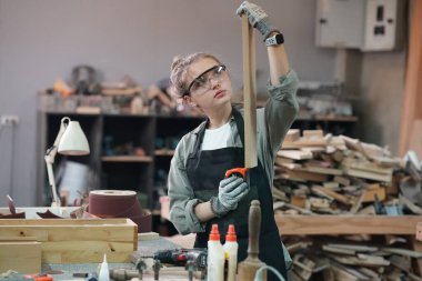 Genç bir kadının küçük işleri. Mobilya atölyesinde çalışan güzel genç bayan.