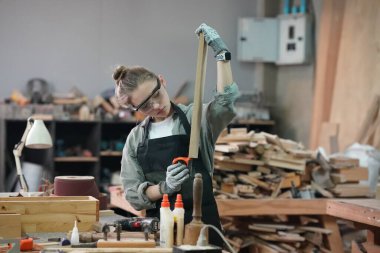 Genç bir kadının küçük işleri. Mobilya atölyesinde çalışan güzel genç bayan.