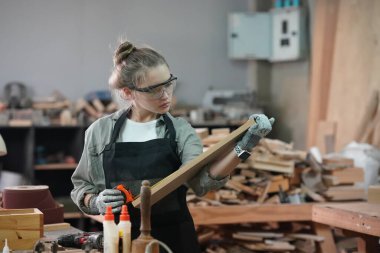 Genç bir kadının küçük işleri. Mobilya atölyesinde çalışan güzel genç bayan.