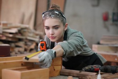 Genç bir kadının küçük işleri. Mobilya atölyesinde çalışan güzel genç bayan.