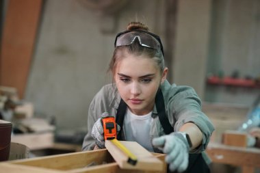 Genç bir kadının küçük işleri. Mobilya atölyesinde çalışan güzel genç bayan.