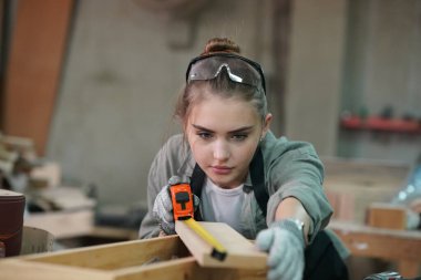 Genç bir kadının küçük işleri. Mobilya atölyesinde çalışan güzel genç bayan.