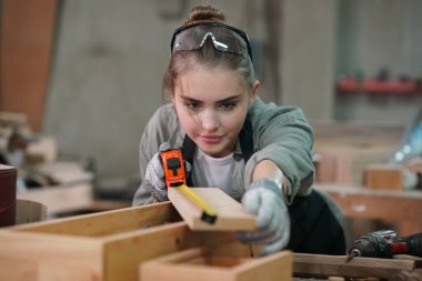 Genç bir kadının küçük işleri. Mobilya atölyesinde çalışan güzel genç bayan.