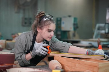 Genç bir kadının küçük işleri. Mobilya atölyesinde çalışan güzel genç bayan.