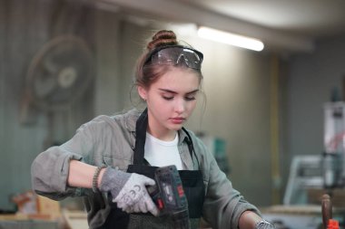 Genç bir kadının küçük işletmesi. Mobilya atölyesinde çalışan güzel genç bayan.