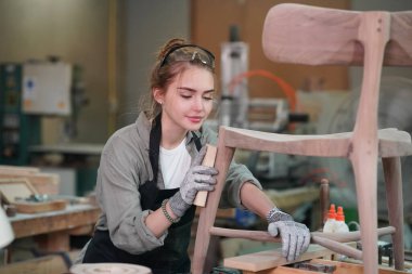 Marangoz DIY atölyesinde çalışan genç ve güzel bir kadın. Küçük işletme sahibi, mobilya fabrikasında çalışan genç bir kadın..