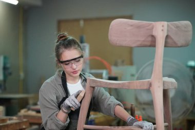 Marangoz DIY atölyesinde çalışan genç ve güzel bir kadın. Küçük işletme sahibi, mobilya fabrikasında çalışan genç bir kadın..