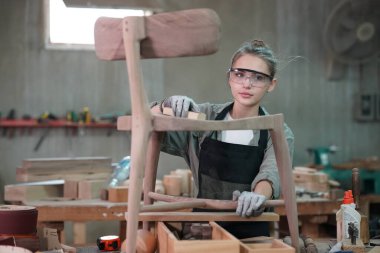 Genç bir kadının küçük işleri. Mobilya atölyesinde çalışan güzel genç bayan.