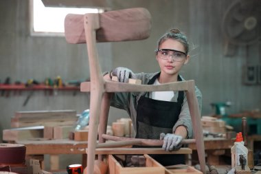 Genç bir kadının küçük işleri. Mobilya atölyesinde çalışan güzel genç bayan.