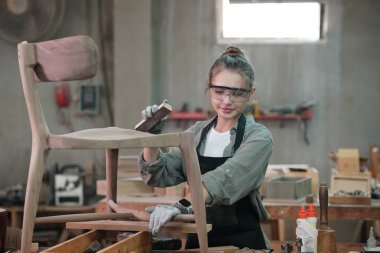 Genç bir kadının küçük işleri. Mobilya atölyesinde çalışan güzel genç bayan.