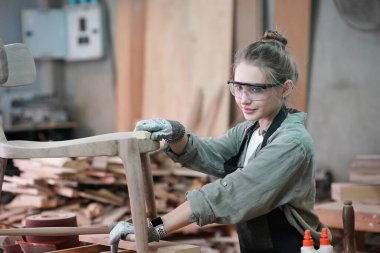 Genç bir kadının küçük işleri. Mobilya atölyesinde çalışan güzel genç bayan.