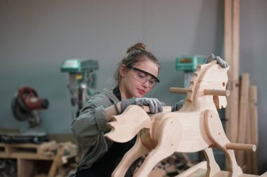 Genç bir kadının küçük işleri. Mobilya atölyesinde çalışan güzel genç bayan.