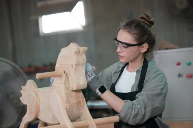 Genç bir kadının küçük işleri. Mobilya atölyesinde çalışan güzel genç bayan.