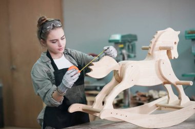 Genç bir kadının küçük işleri. Mobilya atölyesinde çalışan güzel genç bayan.