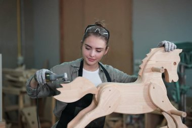 Genç bir kadının küçük işleri. Mobilya atölyesinde çalışan güzel genç bayan.