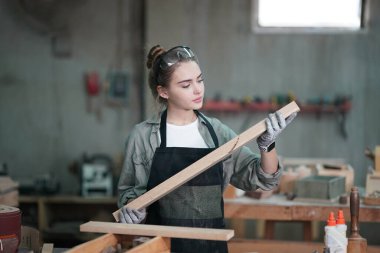 Genç bir kadının küçük işletmesi. Mobilya atölyesinde çalışan güzel genç bayan.