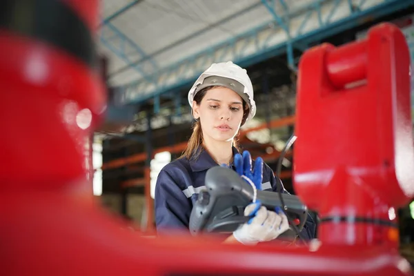 Stock image Robotics engineer working on maintenance of modern robotic arm in factory warehouse