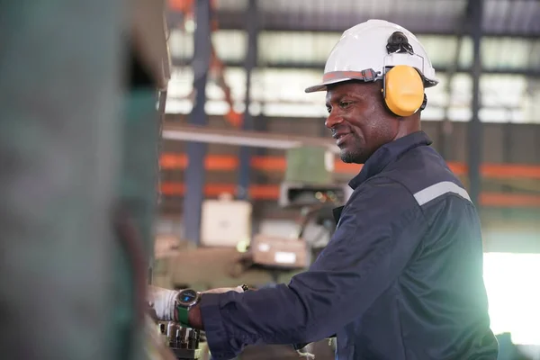 stock image Young successful technician or repairman of industrial machines in safety helmet and workwear  in large garage or workshop